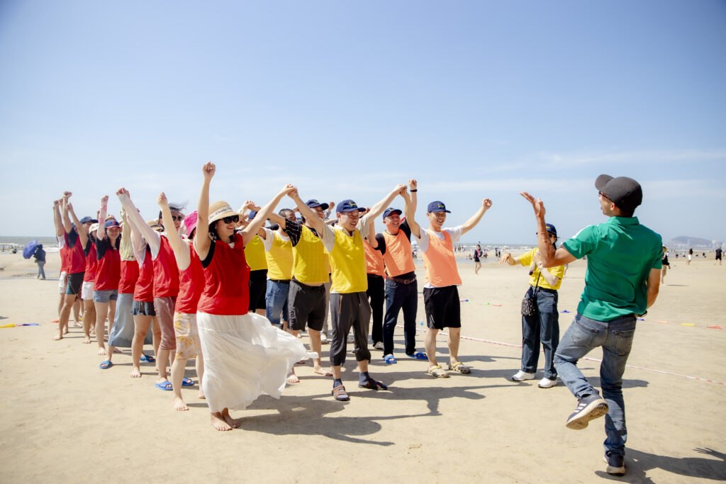 Nhóm học viên tham gia huấn luyện trực tiếp trên bãi biển, thể hiện sự tương tác và gắn kết nhóm, minh họa cho sự khác biệt giữa huấn luyện online và offline