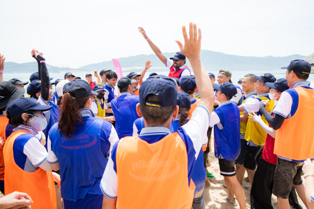 Nhóm học viên tham gia huấn luyện trực tiếp trên bãi biển, thể hiện sự tương tác và gắn kết nhóm, minh họa cho sự khác biệt giữa huấn luyện online và offline.