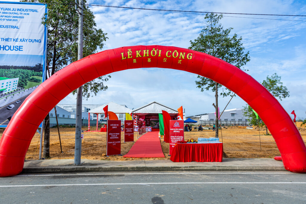 alt= "Không gian trang trí buổi lễ khởi công với cổng chào đỏ và thảm đỏ, hình ảnh minh họa cho thủ tục pháp lý lễ khánh thành chuyên nghiệp và đúng quy định."